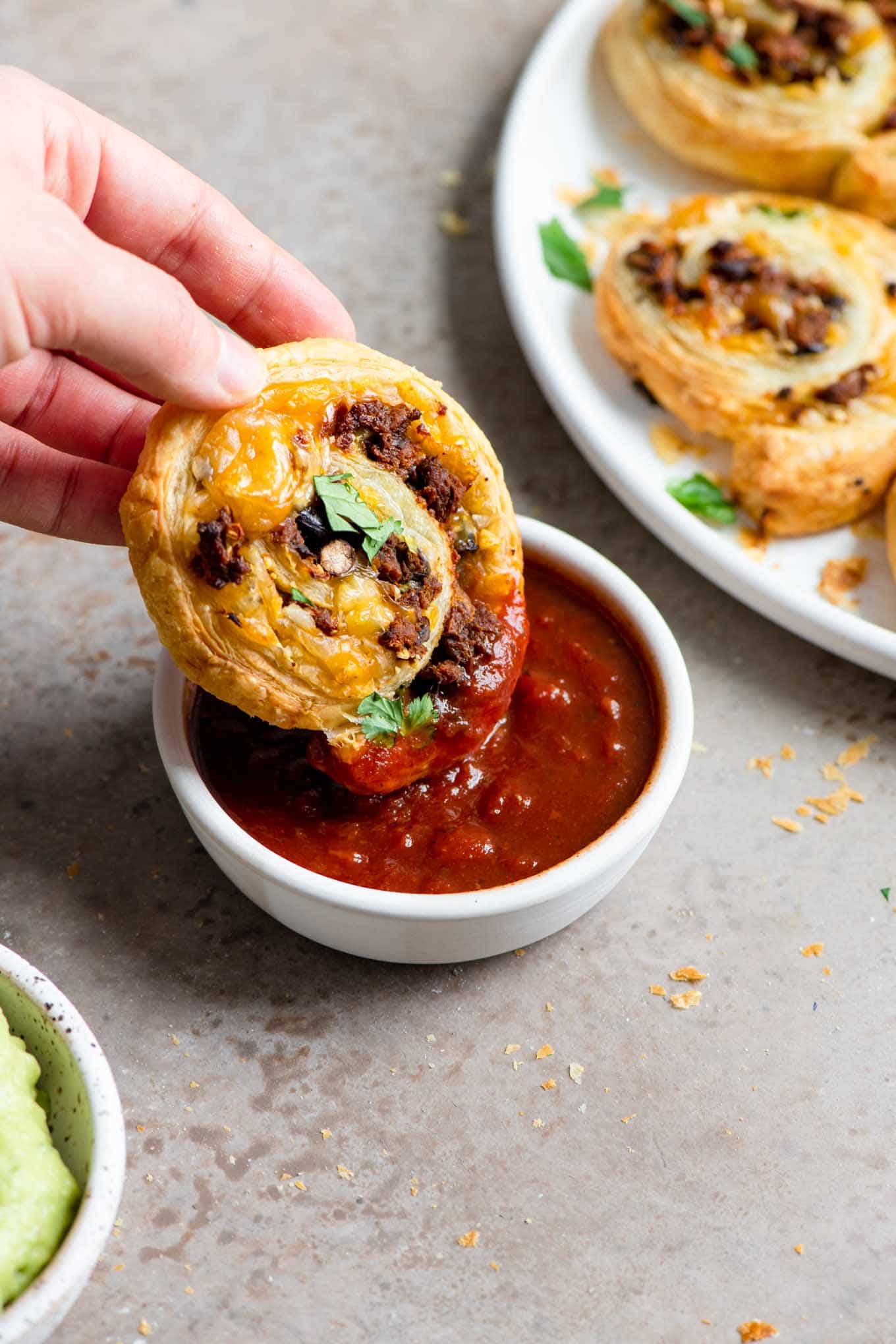 dipping a mexican pinwheel into salsa