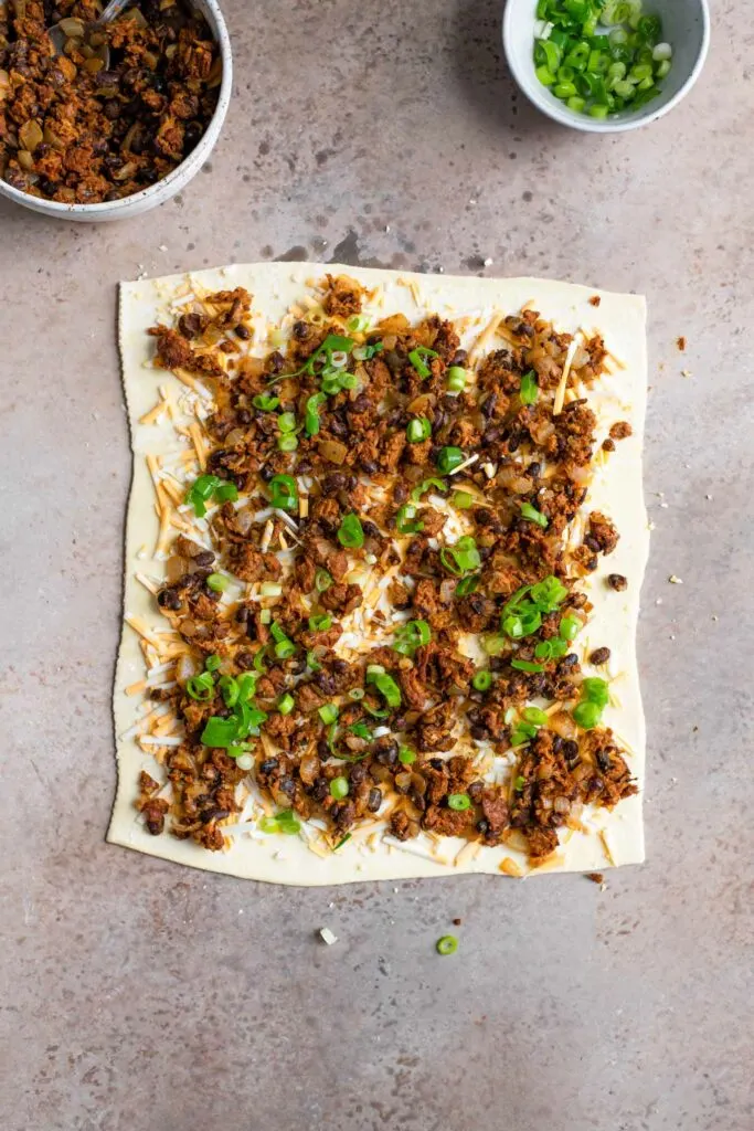 scallions on top of the bean and cheese on the puff pastry