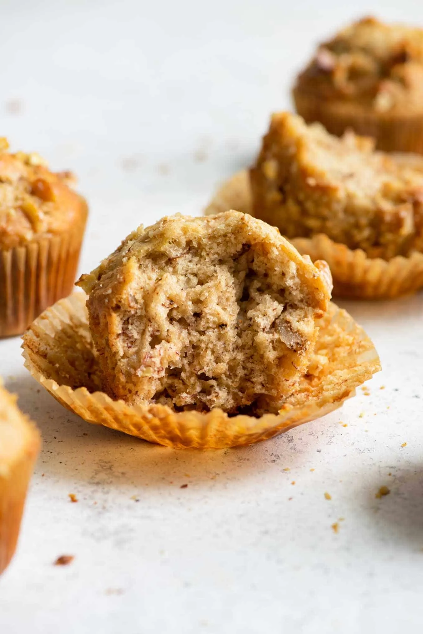 muffin with wrapper peeled off and bite taken out of it to show the crumb