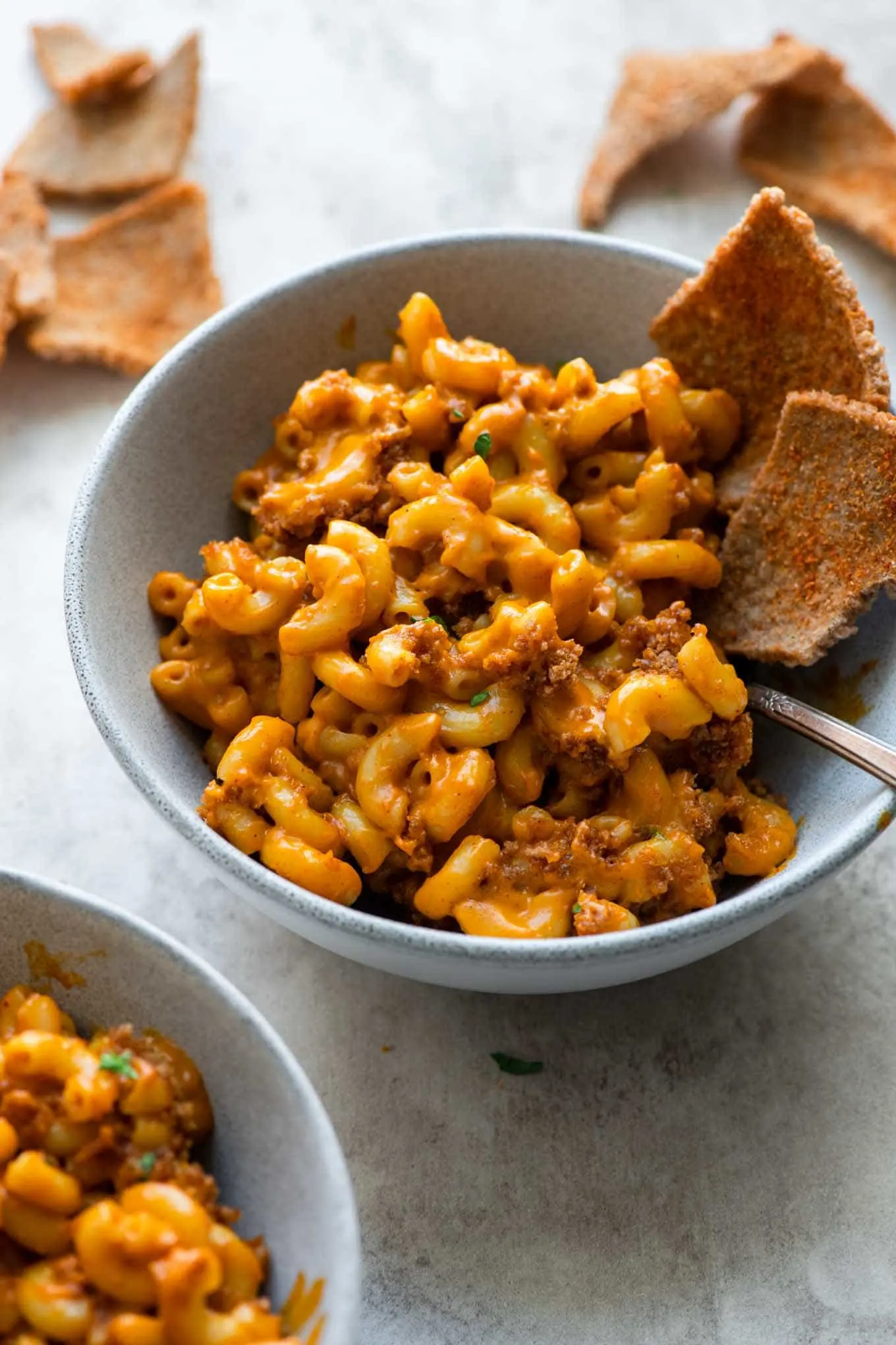 bowl of berbere mac and cheese with injera crisps tucked into it