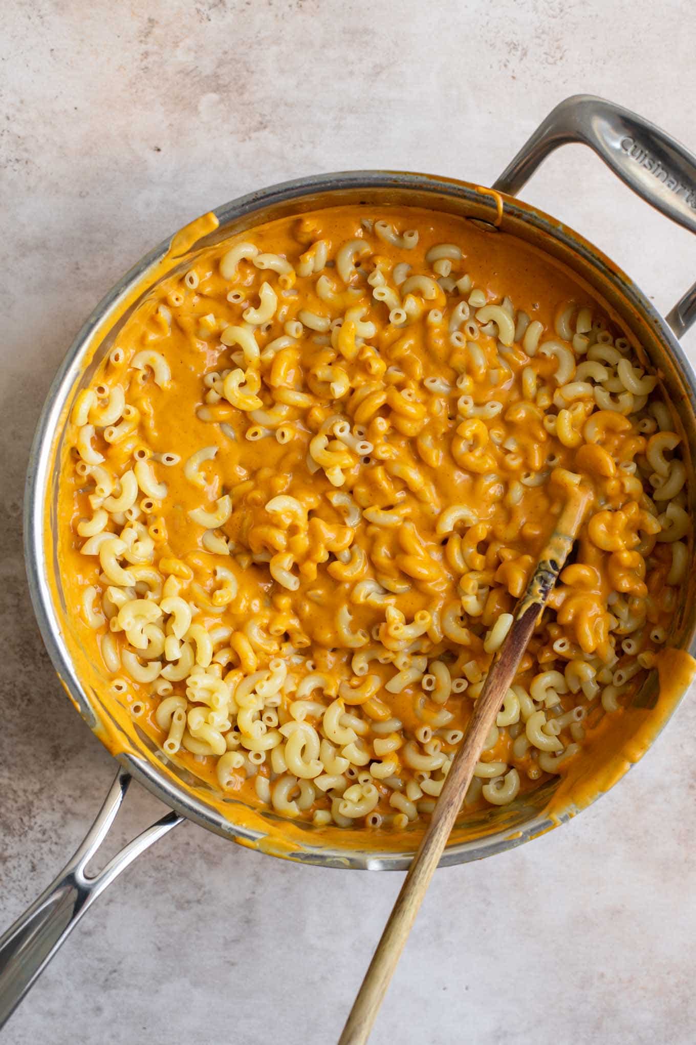 elbow macaroni noodes halfway mixed into the berbere cheese sauce