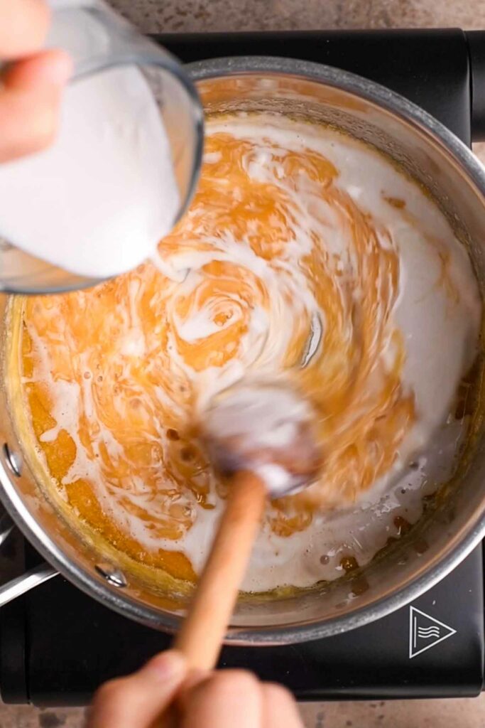 coconut milk being added to caramelized sugar and butter