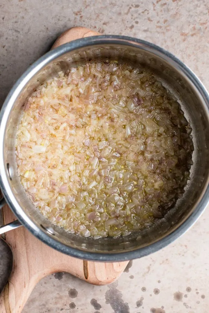 shallots cooked in vegan butter until soft in a small pot