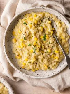sweet corn risotto in a shallow bowl atop a linen napkin