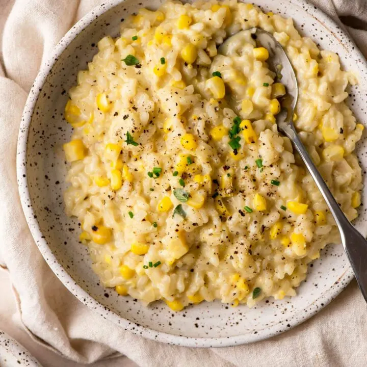 sweet corn risotto in a shallow bowl atop a linen napkin
