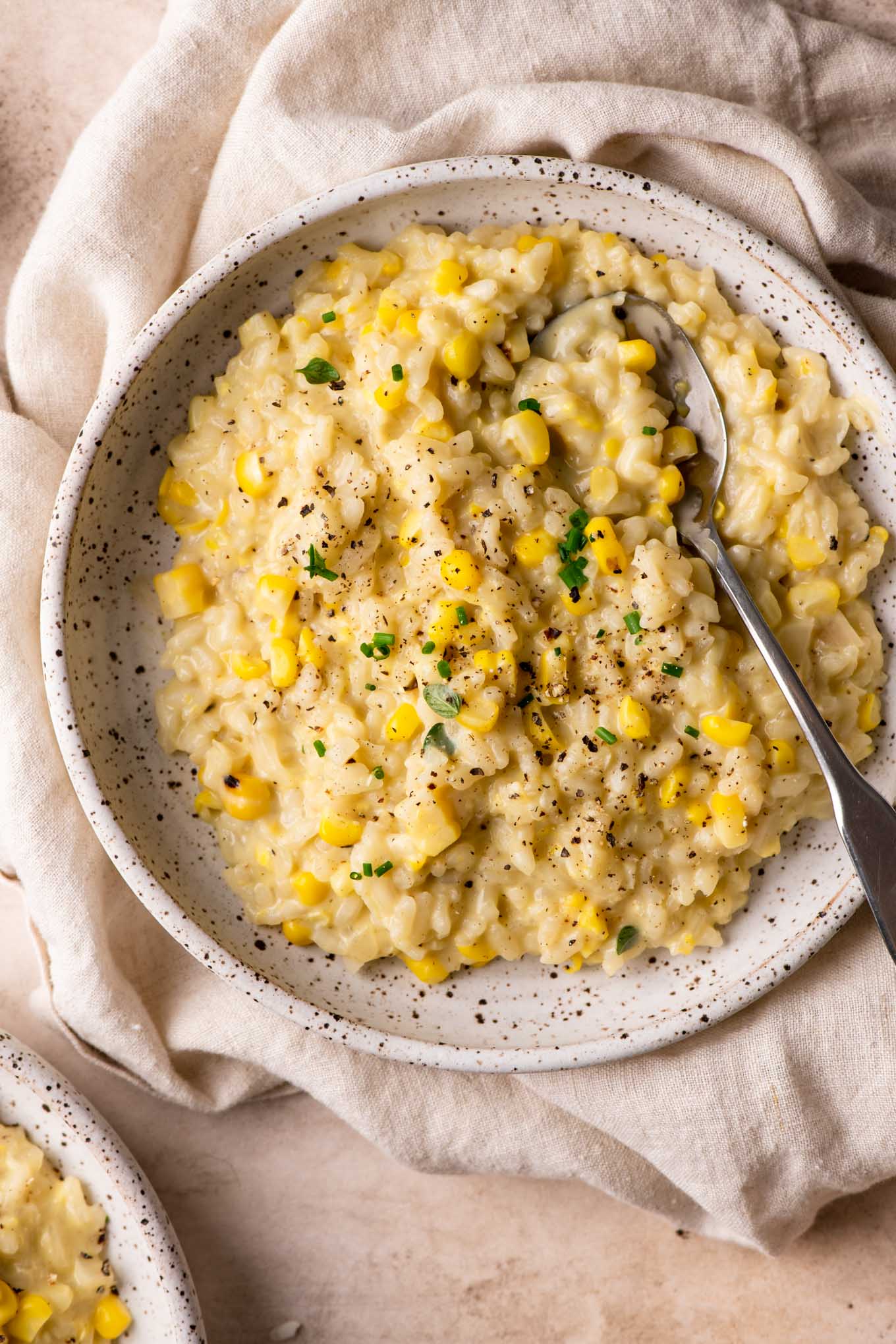 sweet corn risotto in a shallow bowl atop a linen napkin