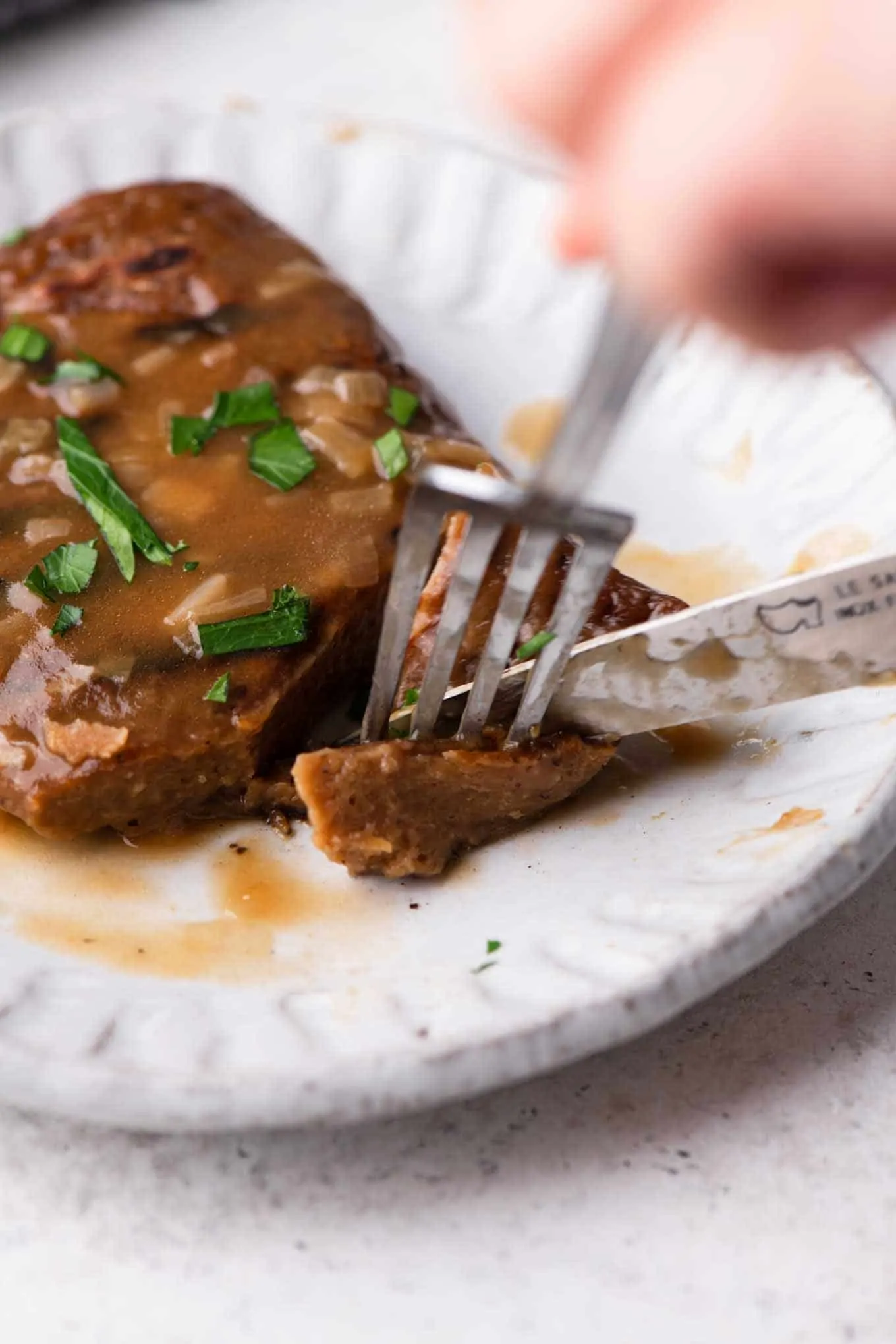 cutting the seitan steaks with a fork and knife