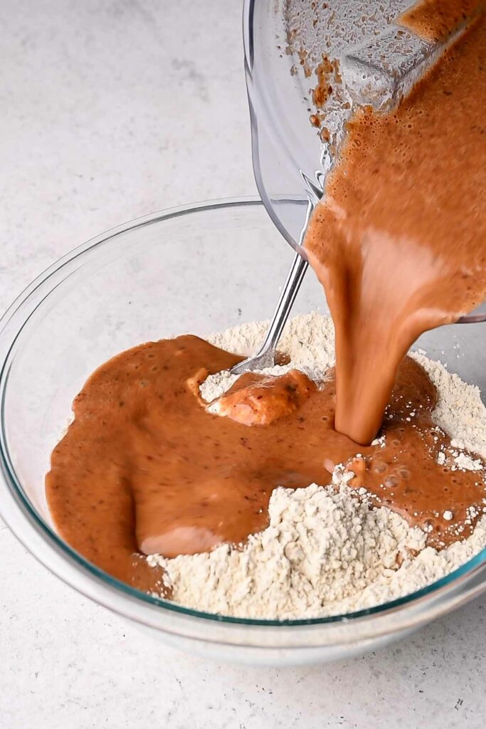 pouring blended wet ingredients into wheat gluten and chickpea flour