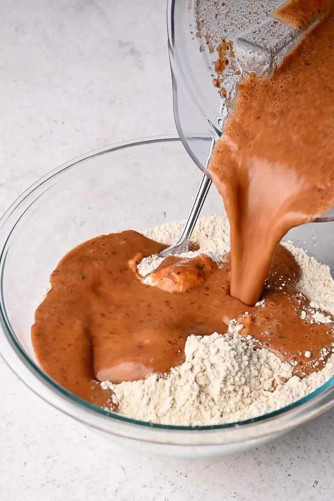 pouring blended wet ingredients into wheat gluten and chickpea flour