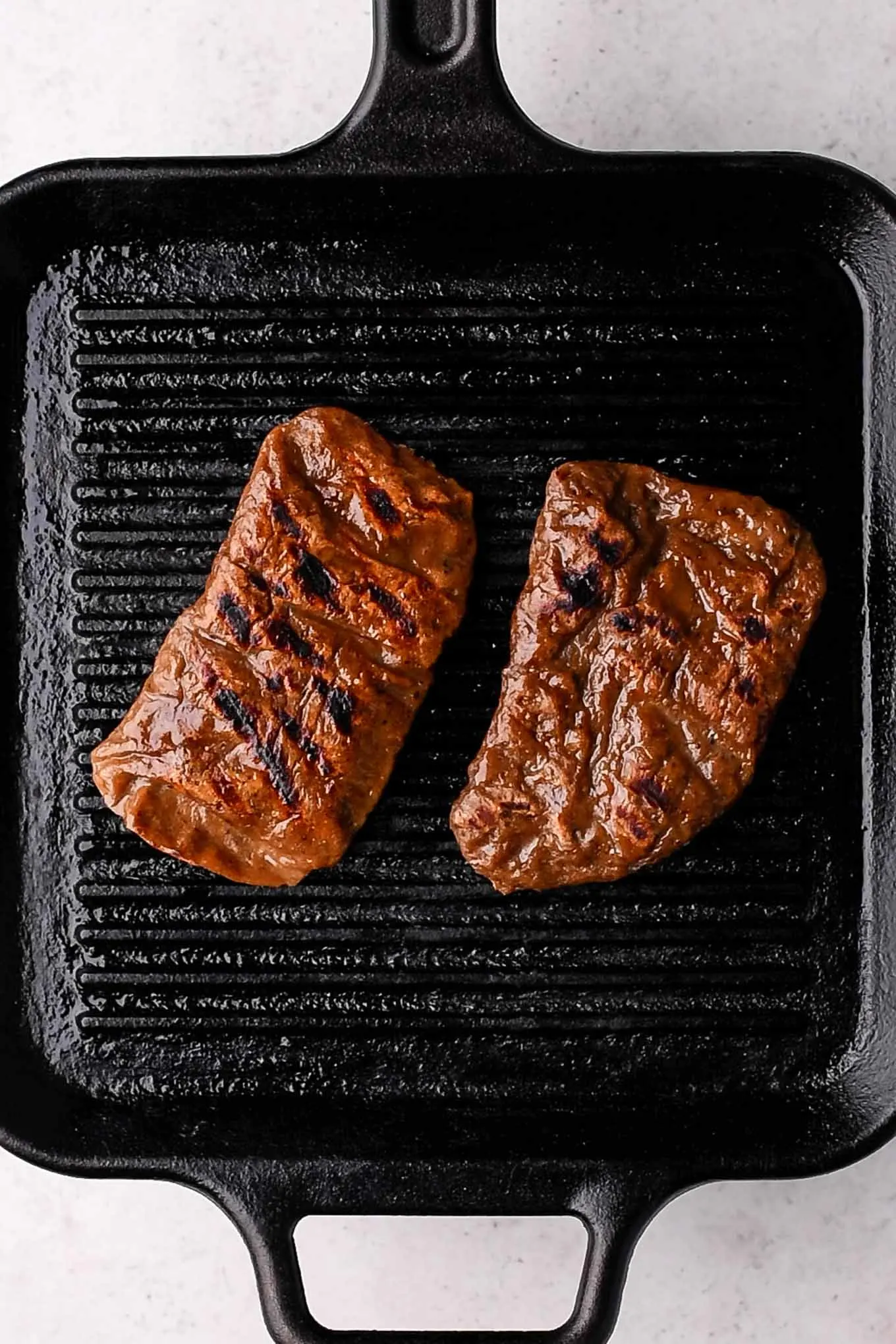 two seitan steaks on grill