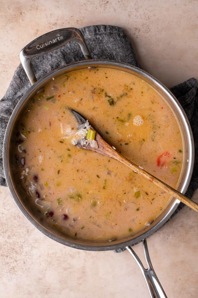 rice just added to cooked beans and seasoning in pot