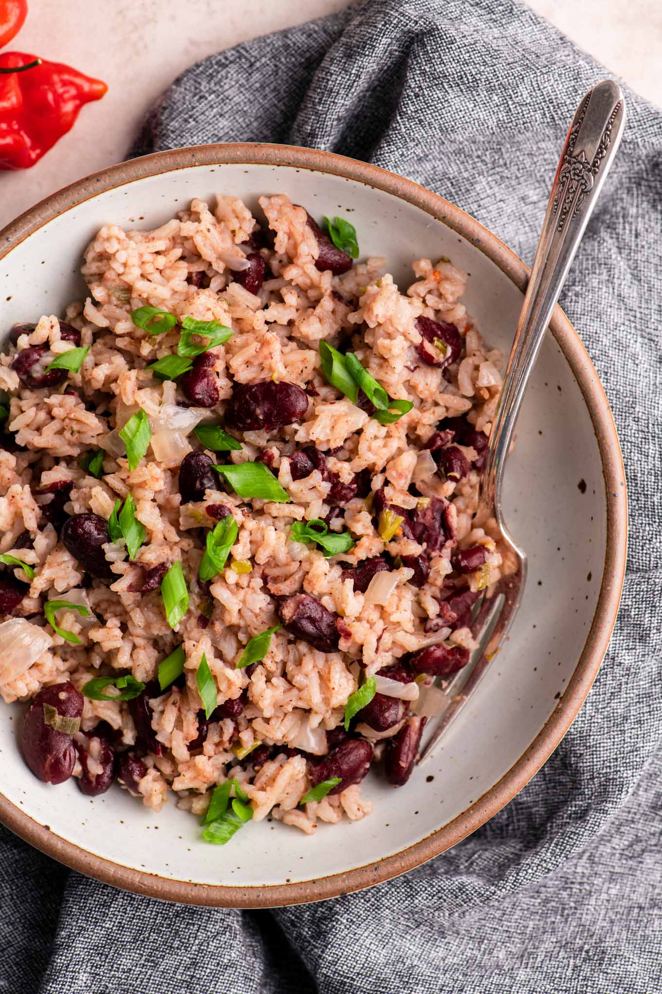 jamaican red rice and beans in a bowl garnished with scallions