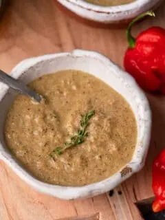 jamaican jerk sauce in small bowl with sprig of thyme for garnish