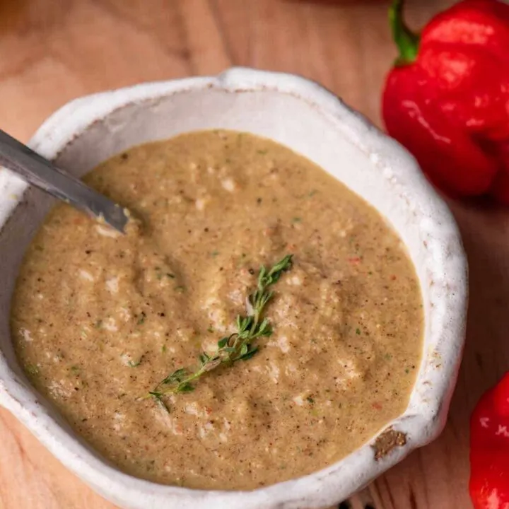 jamaican jerk sauce in small bowl with sprig of thyme for garnish