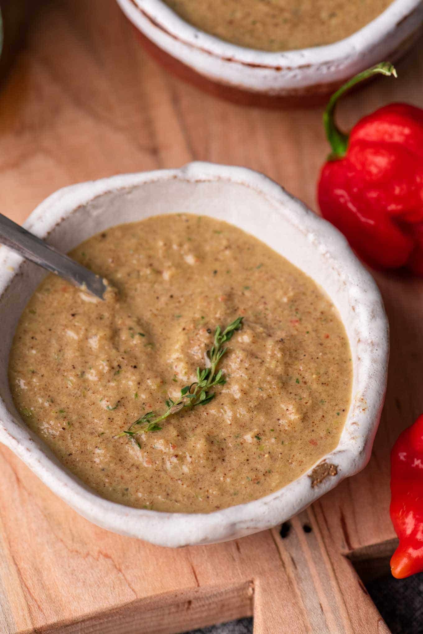 jamaican jerk sauce in small bowl with sprig of thyme for garnish