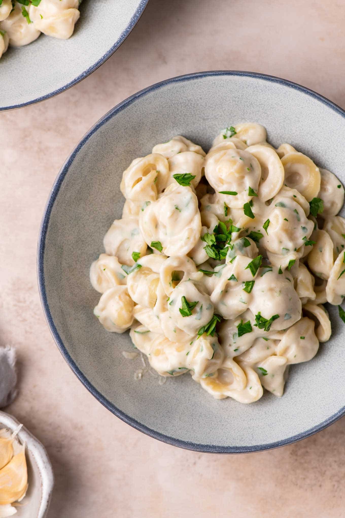 vegan creamy garlic noodles garnished with minced parsley