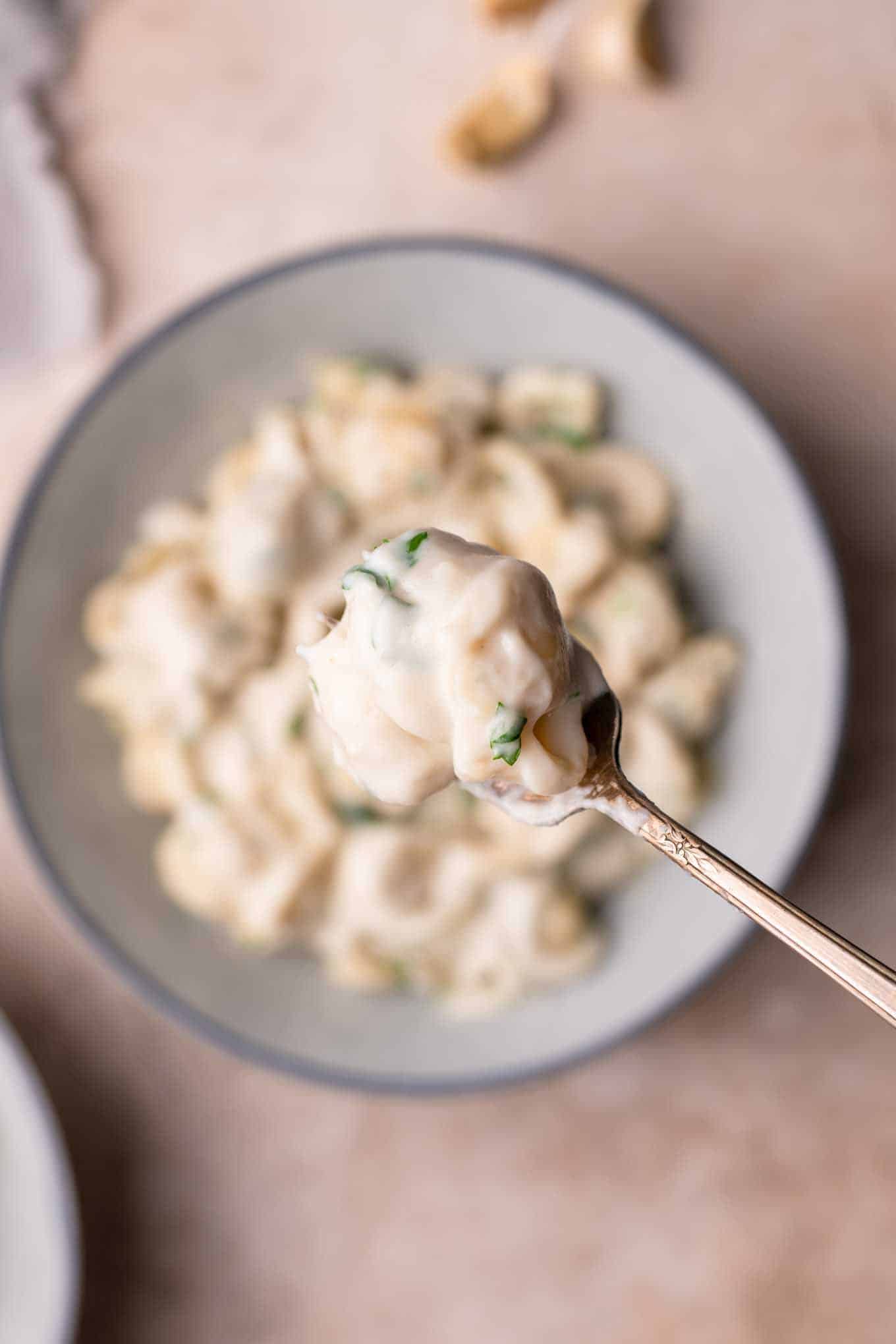 forkful of creamy noodles lifted out of bowl