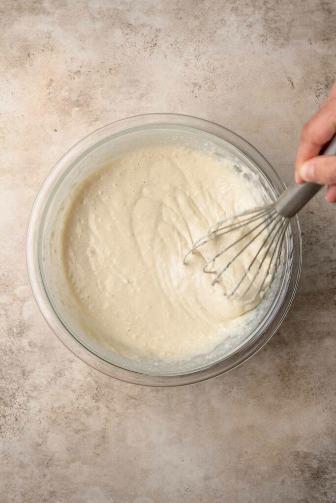 vegan Belgian waffle batter mixed together with a whisk showing the smooth texture of the batter