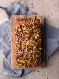 loaf of vegan chocolate chip banana nut bread on a cutting board