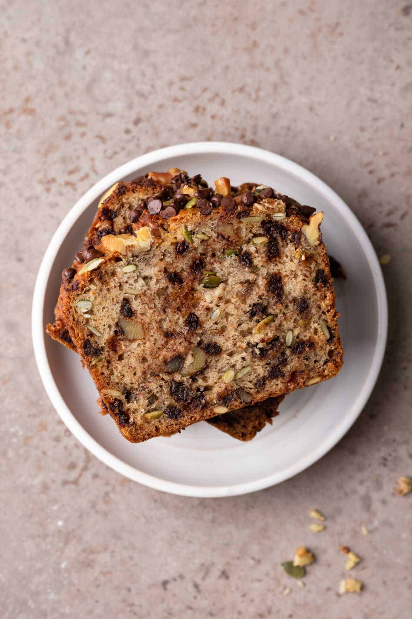 slices of vegan chocolate chip banana nut bread stacked on a plate